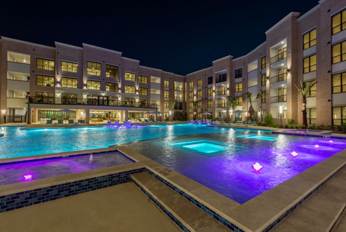 Resort-style pool at night at Boardwalk Square apartments in Katy, Texas