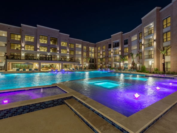Resort-style pool at night at Boardwalk Square apartments in Katy, Texas